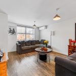 Cosy living room with grey sofas and wooden floor.