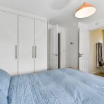 Modern bedroom with ensuite bathroom and wardrobe.