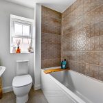 Modern bathroom with patterned tiles and bathtub.