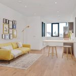 Modern living area with yellow sofa and artwork.