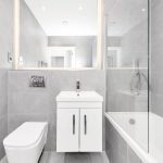 Modern grey tiled bathroom with bath and basin