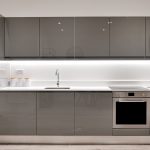 Modern kitchen design with grey cabinets and appliances.