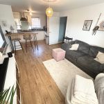 Modern living room and kitchen with wooden flooring.