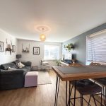 Modern living room with grey sofa and TV display.