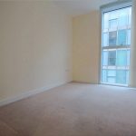 Empty room with large window and radiator