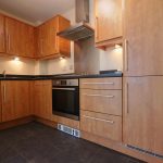 Modern kitchen with wooden cabinets and appliances.