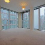 Spacious room with large windows and city view.