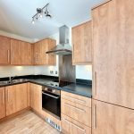 Modern kitchen with wooden cabinets and appliances.