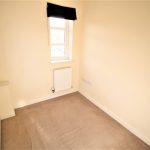 Small empty room with window and radiator