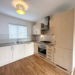 Modern kitchen with wooden cabinets and appliances.