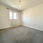 Empty room with grey carpet and window.