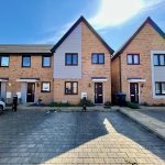 Modern terraced houses with driveways and car.