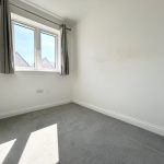 Empty white room with grey curtains and window.