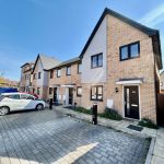 Modern terraced houses with parked cars outside.