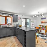 Modern kitchen with grey cabinets and play area.