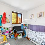 Children's room with toys, bed, and chair.