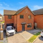 Modern brick house with cars parked outside.
