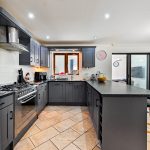 Modern kitchen with dark cabinets and appliances.