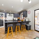 Modern kitchen with island and bar stools.