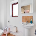 Small bathroom with sink, toilet, and towel.