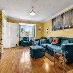 Bright living room with teal sofas and wooden floor.