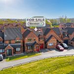 Houses for sale in British suburb with sunny sky.