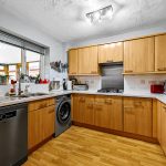 Modern kitchen with wooden cabinets and appliances.
