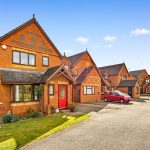 Modern brick houses on a sunny residential street.