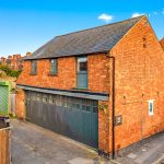 Red brick garage with residential flat above.