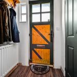 Entrance hall with wooden door and coat rack.