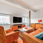 Modern living room with cosy seating and TV.