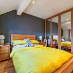 Cosy bedroom with yellow bedding and stuffed toy.