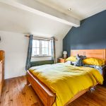 Cosy bedroom with yellow bedding and wooden furniture.