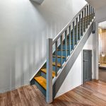 Wooden staircase and modern bathroom in a hallway.