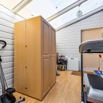 Home gym with equipment and wardrobe in conservatory.