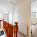 Upper hallway with wooden railing, four doors visible.