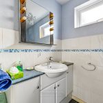 Modern bathroom with blue accents and white tiles.
