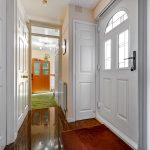 Bright hallway with doors and wooden flooring.