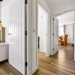 Modern hallway leading to bedroom and dining room.