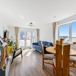 Bright living room with dining area and large windows.