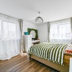 Bright bedroom with striped bedding and modern decor.