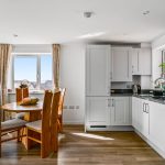 Modern kitchen and dining area with wooden furniture.