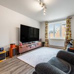 Cosy living room with large TV and sofa.