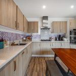 Modern kitchen with wooden cabinets and dining table.