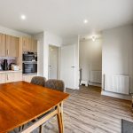 Modern kitchen with wooden table and appliances.