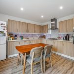 Modern kitchen with wooden cabinets and dining table.