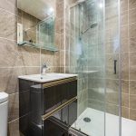 Modern bathroom with shower and sink.