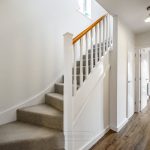 Modern hallway with staircase and wooden flooring