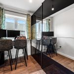 Modern home office with dual monitors and chairs.