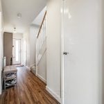 Bright hallway with wooden floor and stairs